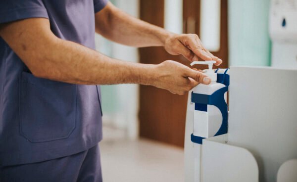 Male nurse disinfecting his hands